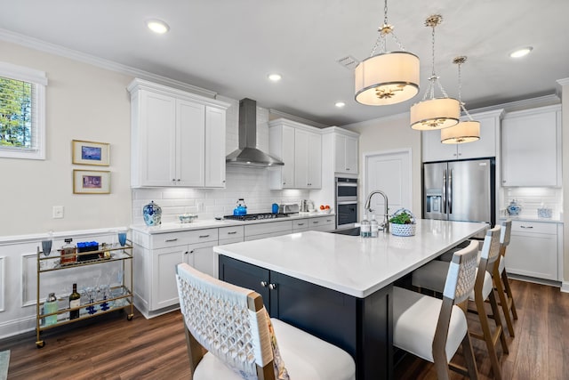 kitchen with white cabinets, hanging light fixtures, and wall chimney range hood