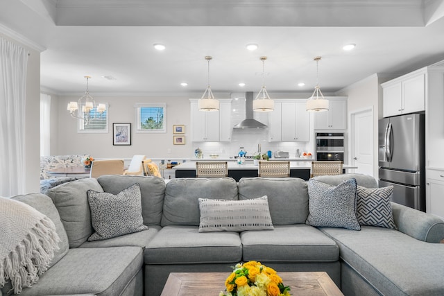 living room with crown molding and an inviting chandelier