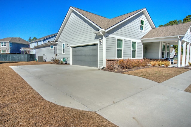 view of home's exterior featuring a porch, a garage, and central air condition unit