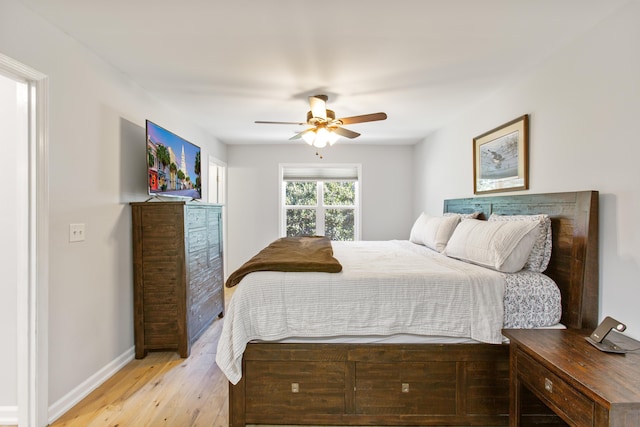 bedroom with ceiling fan, light wood finished floors, and baseboards