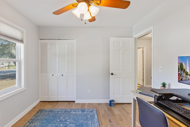 office with light wood-type flooring, baseboards, and a ceiling fan