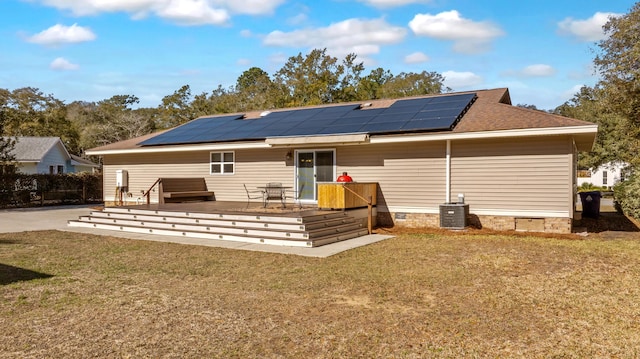 back of house featuring solar panels, a lawn, crawl space, a wooden deck, and central AC