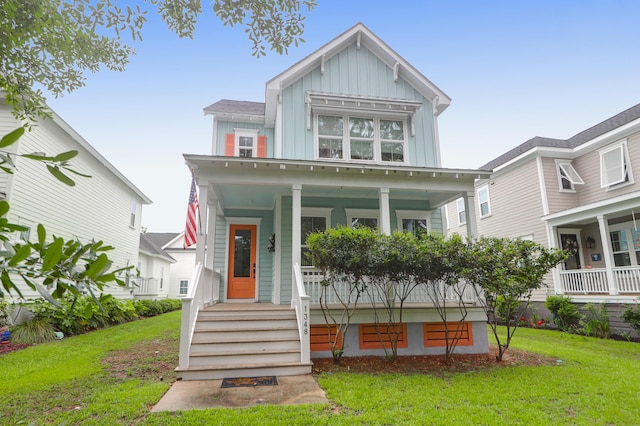 view of front facade with board and batten siding, a porch, and a front lawn