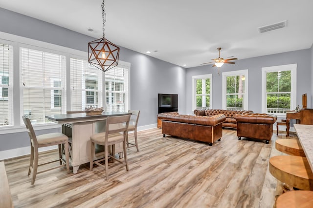 living area with light wood finished floors, healthy amount of natural light, baseboards, and recessed lighting