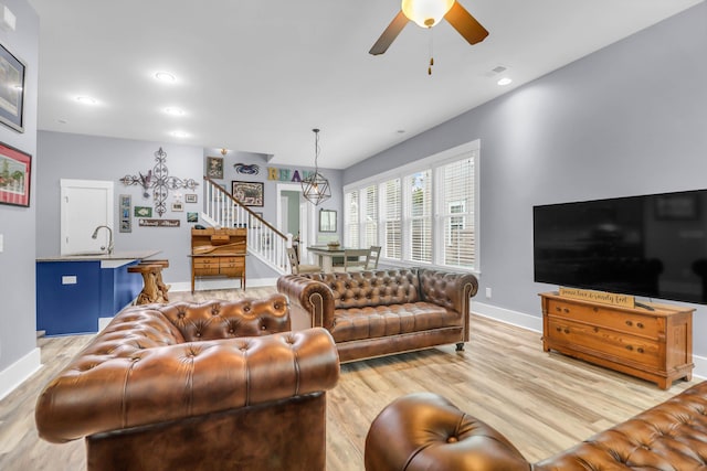 living area with stairway, baseboards, light wood-style flooring, a ceiling fan, and recessed lighting