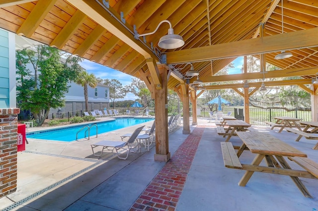 community pool with fence, a patio area, and a gazebo
