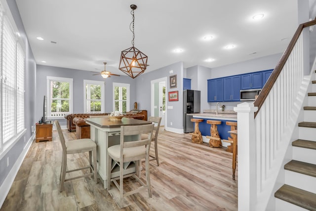 dining space featuring stairs, light wood finished floors, baseboards, and recessed lighting