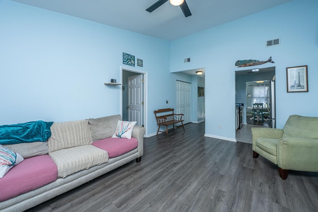 living area with wood finished floors, ceiling fan, high vaulted ceiling, and baseboards
