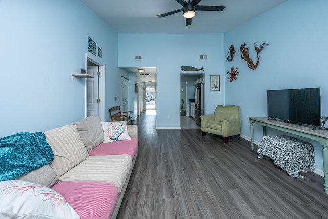 living area featuring wood finished floors, a ceiling fan, and baseboards