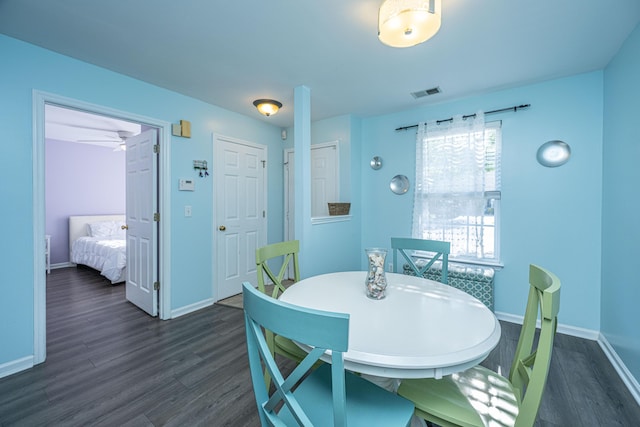 dining area with dark wood-style flooring and baseboards