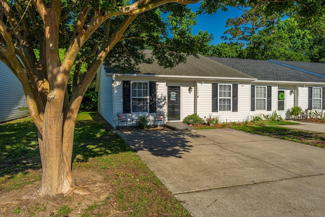 view of front facade featuring roof with shingles and a front yard