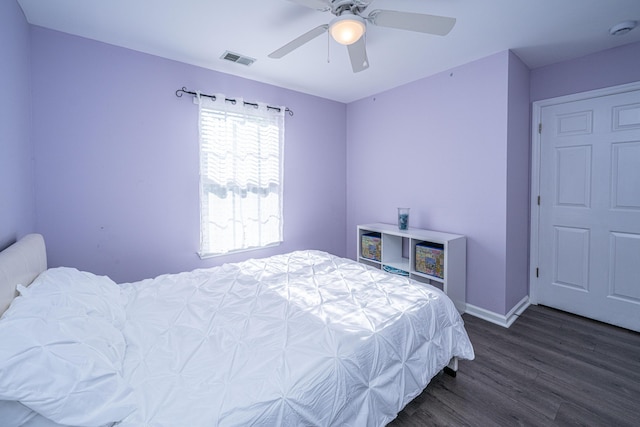 bedroom with dark wood-type flooring, a ceiling fan, and baseboards