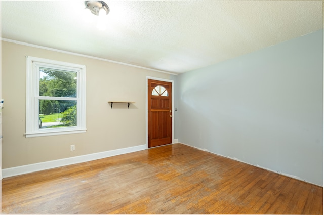 entryway with light wood-type flooring and a textured ceiling