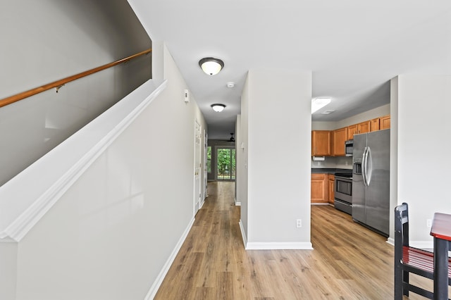 kitchen with stainless steel appliances, ceiling fan, and light wood-type flooring