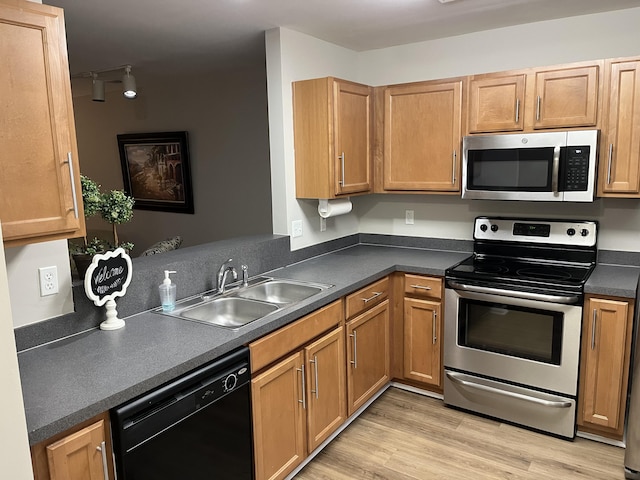 kitchen featuring track lighting, appliances with stainless steel finishes, light hardwood / wood-style floors, and sink