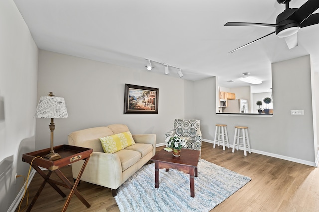 living room featuring ceiling fan and light wood-type flooring