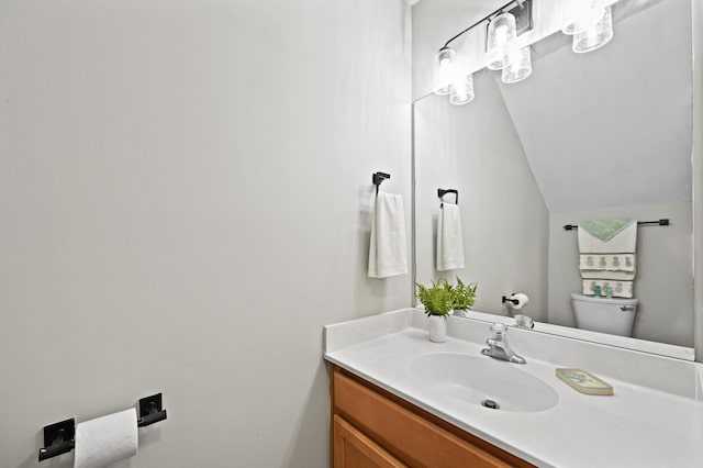 bathroom with vanity, vaulted ceiling, and toilet