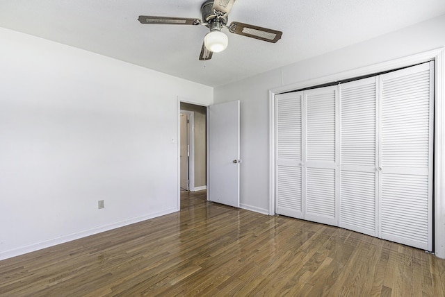 unfurnished bedroom featuring a textured ceiling, a closet, ceiling fan, and dark wood-type flooring