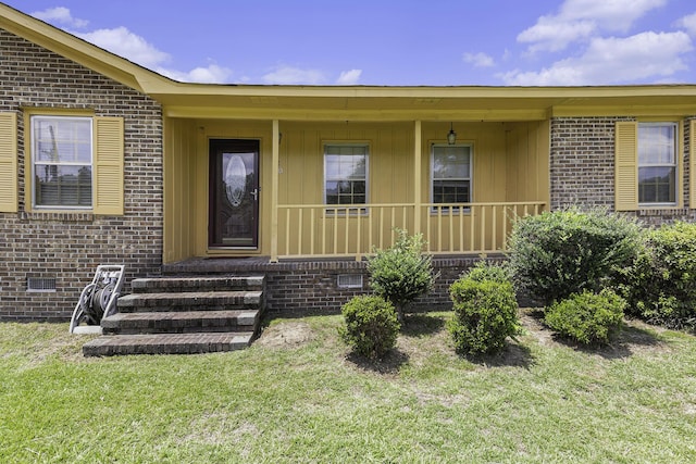 doorway to property featuring a lawn