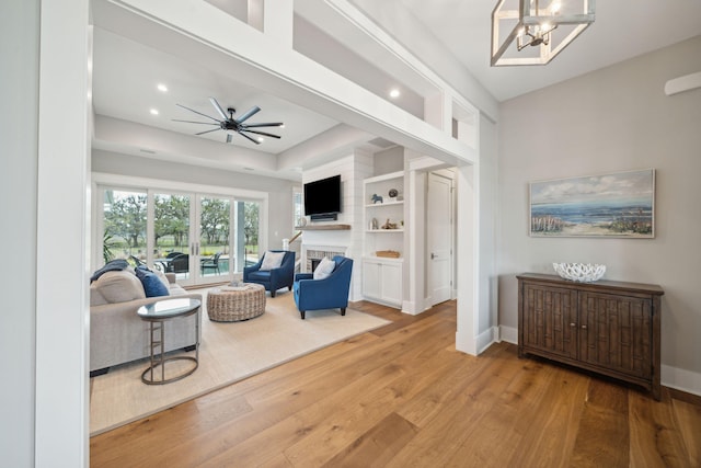 living room with ceiling fan with notable chandelier, recessed lighting, wood finished floors, and baseboards