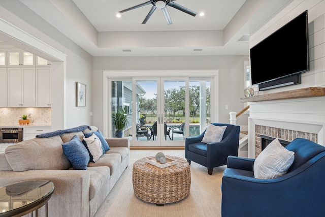 living room with a ceiling fan, a brick fireplace, french doors, and visible vents