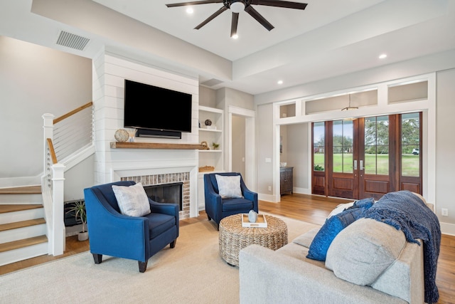 living area featuring stairs, french doors, baseboards, and light wood-style floors