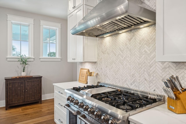 kitchen featuring wood finished floors, white cabinetry, high end stainless steel range, range hood, and tasteful backsplash