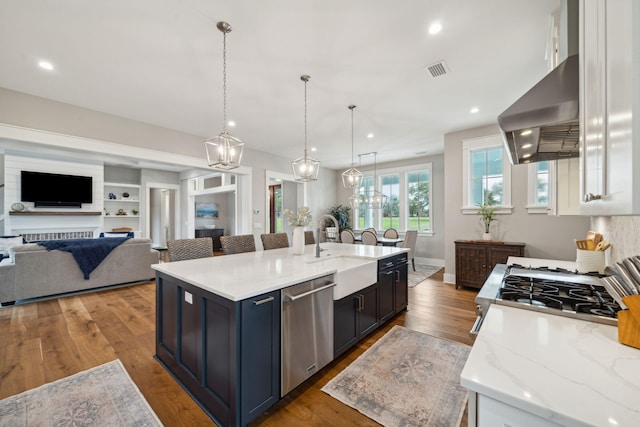 kitchen featuring open floor plan, white cabinetry, dishwasher, and a sink