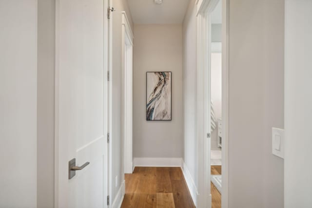 hallway featuring wood finished floors and baseboards