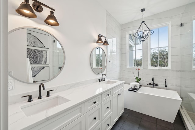 bathroom with tile patterned floors, a freestanding tub, a sink, and double vanity