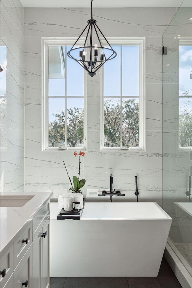 bathroom featuring a freestanding bath, plenty of natural light, and vanity