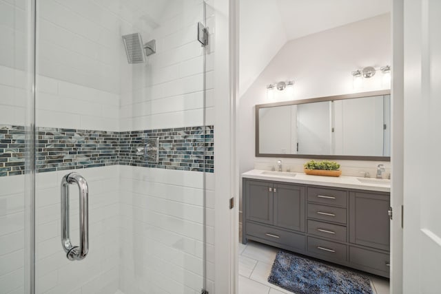 bathroom featuring tile patterned floors, a sink, a shower stall, and double vanity