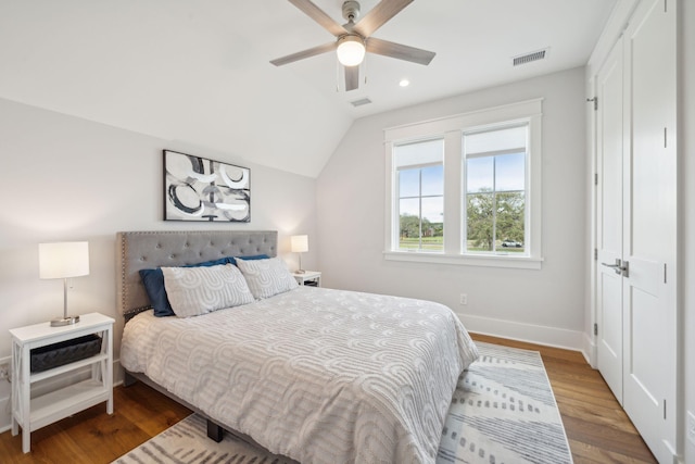 bedroom featuring visible vents, vaulted ceiling, baseboards, and wood finished floors