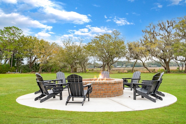 view of community with a patio area, a fire pit, and a yard