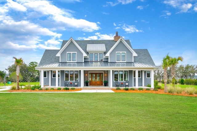 rear view of property featuring a standing seam roof, a porch, french doors, and a yard