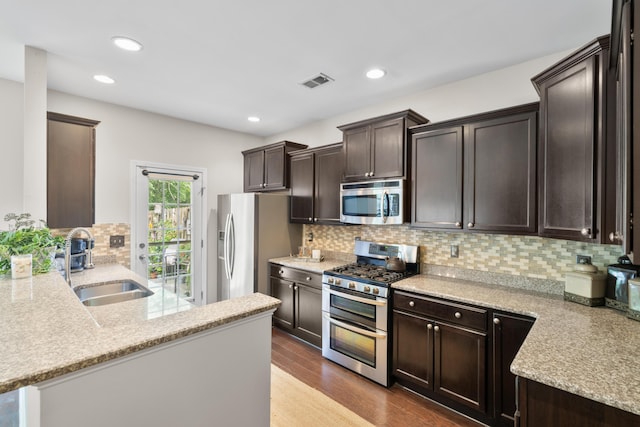 826 Bibury Ct, Charleston, SC 29414 - kitchen with stainless steel appliances, a sink, dark brown cabinets, light stone counters, and backsplash