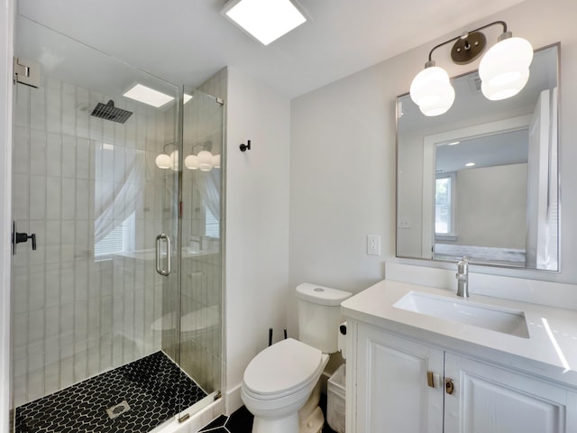 bathroom with vanity, toilet, and a shower with door