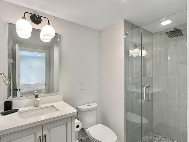 bathroom featuring a shower with door, vanity, and toilet