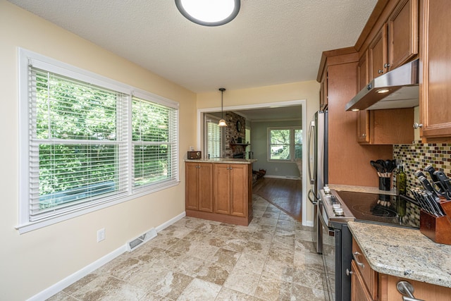 2847 Limestone Blvd, Charleston, SC 29414 - kitchen with under cabinet range hood, electric range oven, brown cabinetry, freestanding refrigerator, and tasteful backsplash
