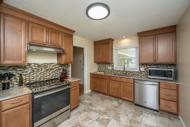 2847 Limestone Blvd, Charleston, SC 29414 - kitchen with stainless steel appliances, under cabinet range hood, brown cabinets, and a textured ceiling