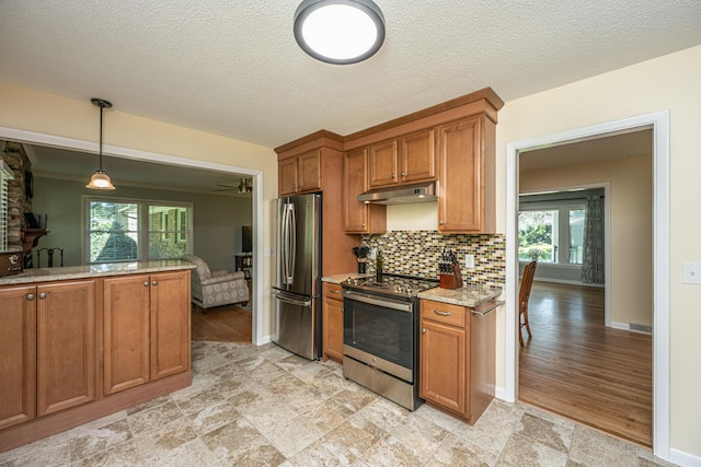 2847 Limestone Blvd, Charleston, SC 29414 - kitchen featuring stainless steel appliances, under cabinet range hood, brown cabinetry, decorative backsplash, and pendant lighting