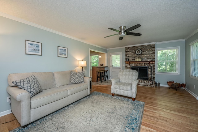 2847 Limestone Blvd, Charleston, SC 29414 - living room featuring light wood-type flooring, ornamental molding, a ceiling fan, a textured ceiling, and a brick fireplace