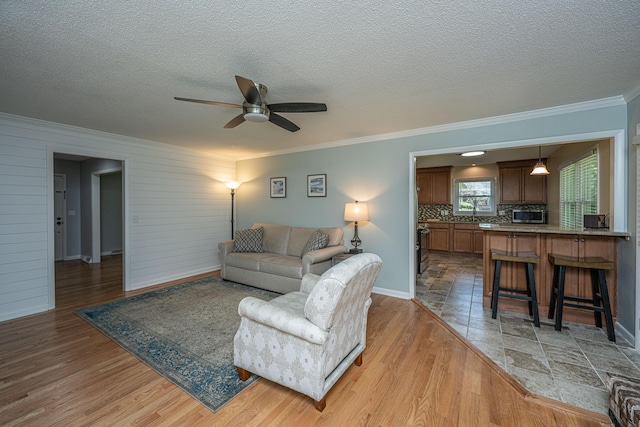 2847 Limestone Blvd, Charleston, SC 29414 - living room with light wood-style flooring, ceiling fan, ornamental molding, and a textured ceiling