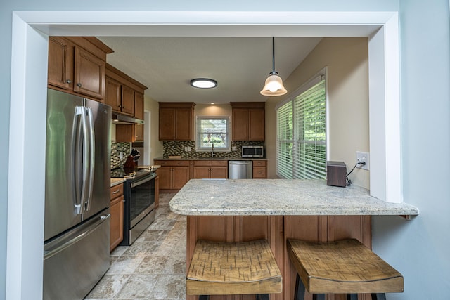 2847 Limestone Blvd, Charleston, SC 29414 - kitchen featuring stainless steel appliances, decorative backsplash, a peninsula, under cabinet range hood, and a breakfast bar area