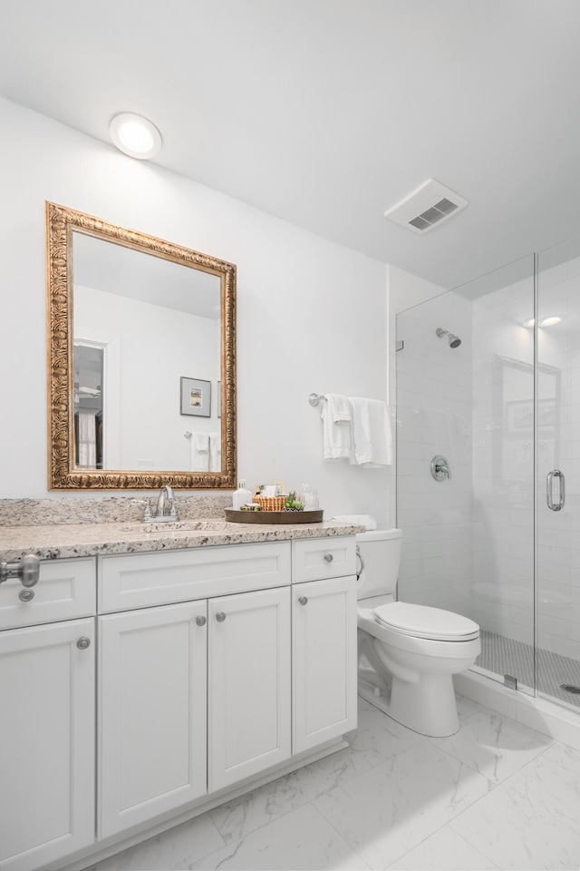 bathroom with vanity, a shower with shower door, and toilet