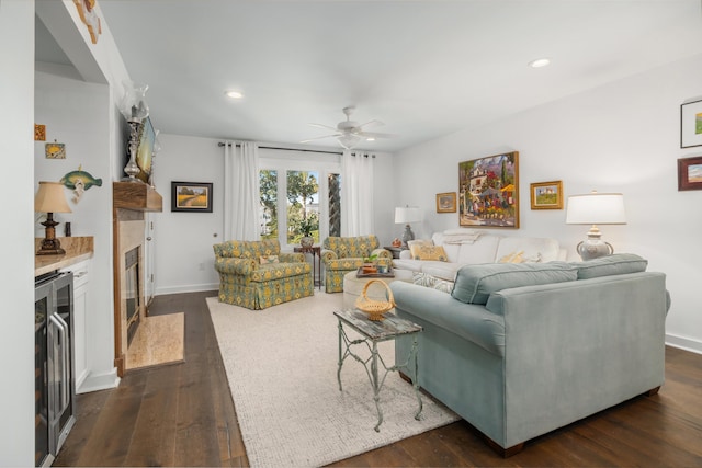 living room with dark hardwood / wood-style floors, ceiling fan, a fireplace, and wine cooler