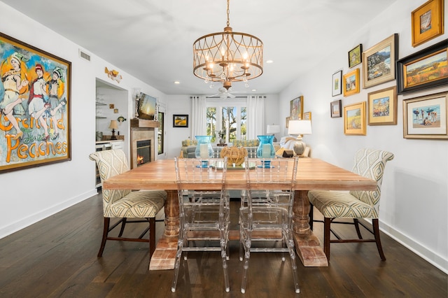 dining area featuring dark hardwood / wood-style flooring and an inviting chandelier