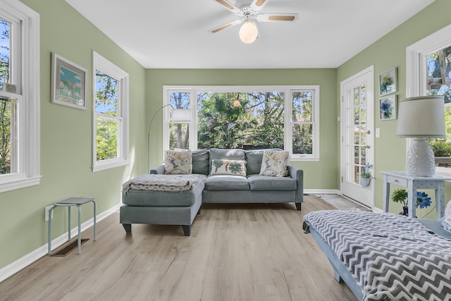 sunroom with baseboards, wood finished floors, and healthy amount of natural light