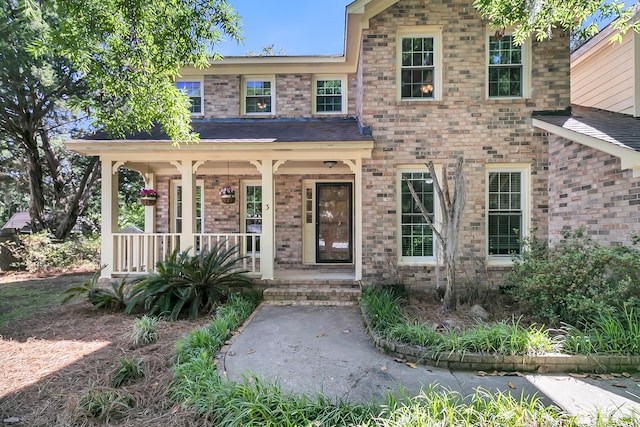 traditional-style house with covered porch and brick siding