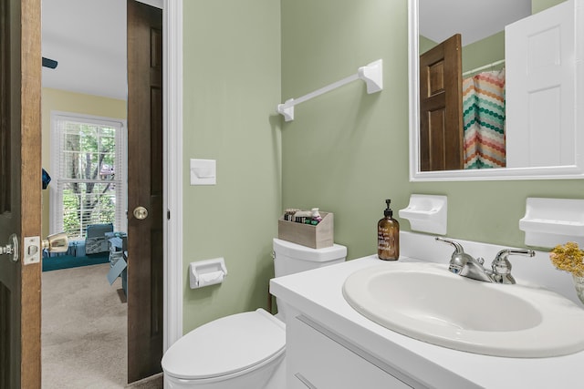full bath featuring toilet, vanity, and a shower with shower curtain